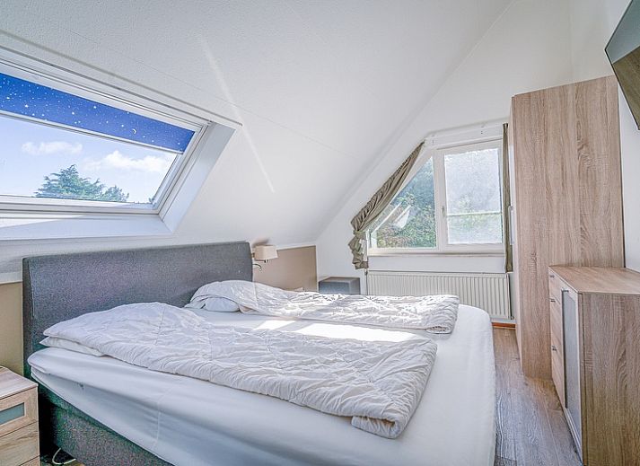 Cozy living room of Holiday home Honeysuckle 95 in De Koog, Texel with comfortable sofas and fireplace.