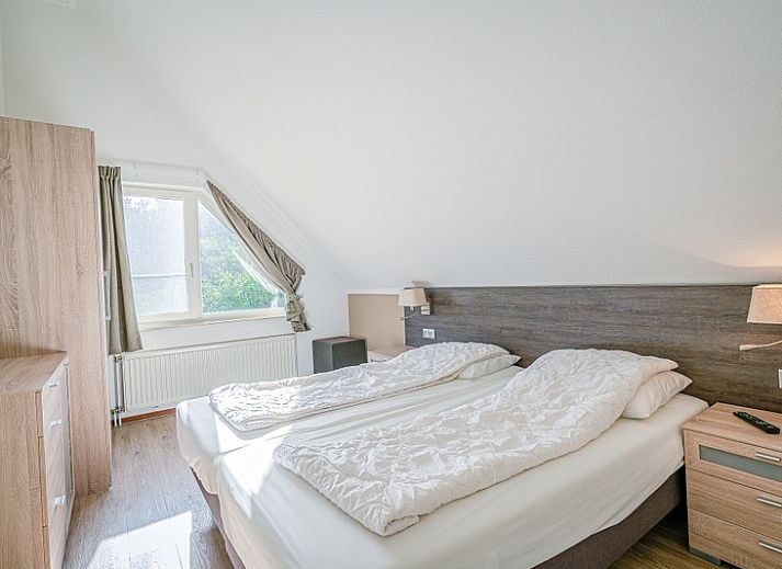 Cozy living room of Holiday home Honeysuckle 95 in De Koog, Texel with comfortable sofas and fireplace.