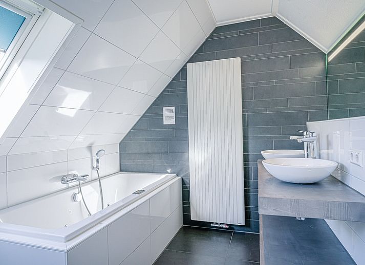 Cozy living room of Holiday home Honeysuckle 95 in De Koog, Texel with comfortable sofas and fireplace.