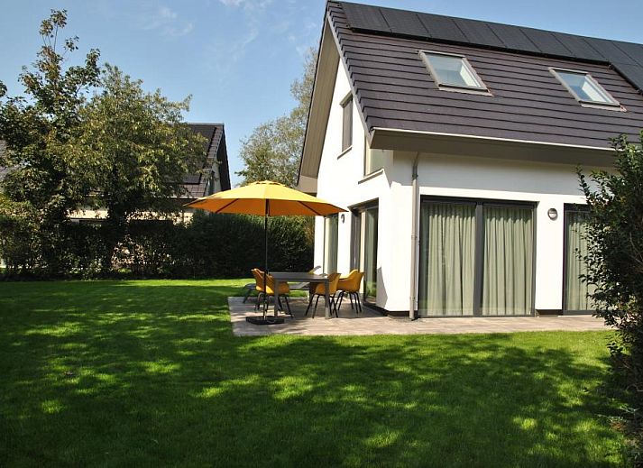 Vakantiehuis Grutto 16 in De Koog, Texel, omgeven door groene tuin en moderne architectuur voor een ontspannen verblijf op de Waddeneilanden.