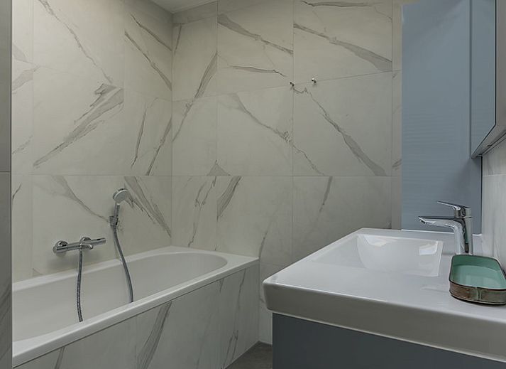 Stijlvolle woonkamer van Zilte Bries vakantiehuis in De Koog, Texel met kunst aan de muur.