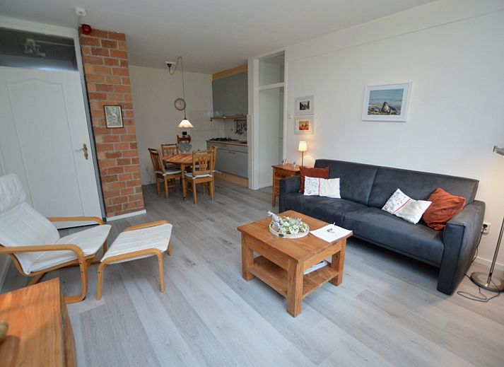Gezellige woonkamer in Appartement Kerckeland 20, De Koog, Texel met comfortabele zithoek en eetruimte.