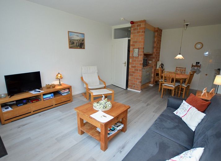 Lichte woonkamer van Appartement Kerckeland 20, De Koog, Texel met uitzicht op de groene omgeving.