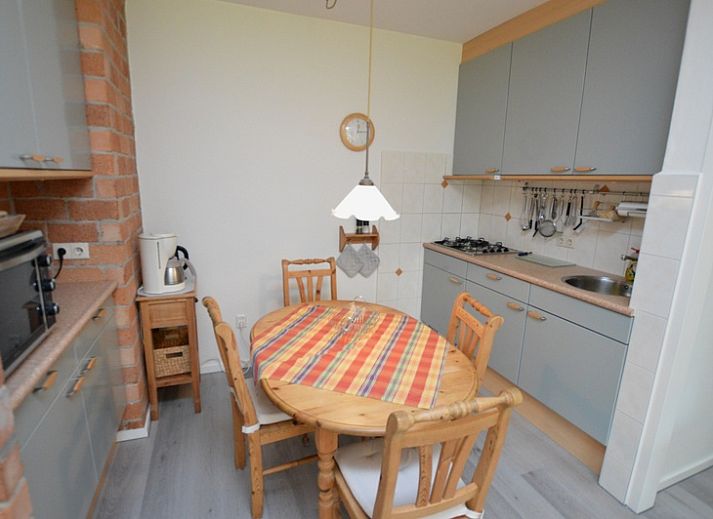 Lichte woonkamer van Appartement Kerckeland 20, De Koog, Texel met uitzicht op de groene omgeving.