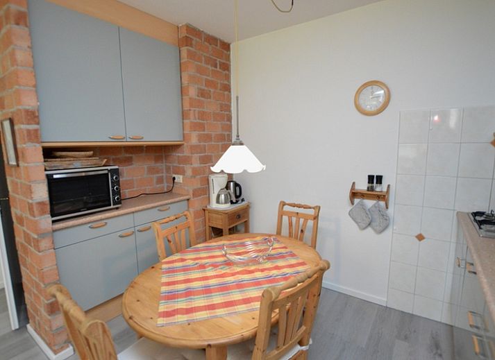 Lichte woonkamer van Appartement Kerckeland 20, De Koog, Texel met uitzicht op de groene omgeving.