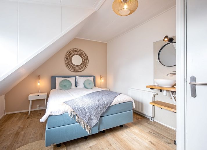 Attraktives Schlafzimmer in De Strandleeuwerik, Ferienhaus in De Koog, Texel mit bequemem Doppelbett und moderner Einrichtung.