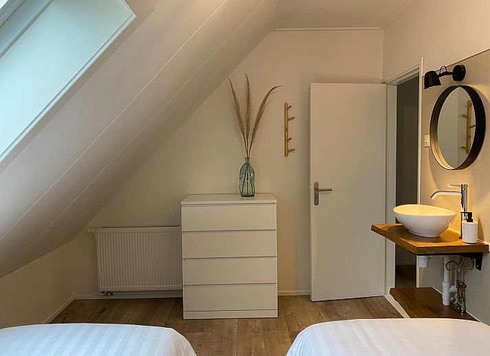 Gemuetliche Ecke des Schlafzimmers in De Strandleeuwerik, Ferienhaus in De Koog, Texel mit weicher Bettwaesche und natuerlichem Licht.