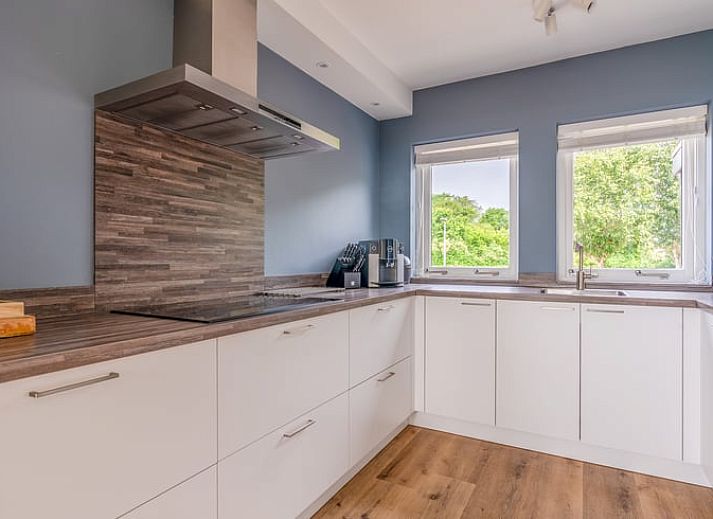 Gezellige woonkamer van Huisje in De Koog, Texel, met uitzicht op het landschap van de Waddeneilanden.