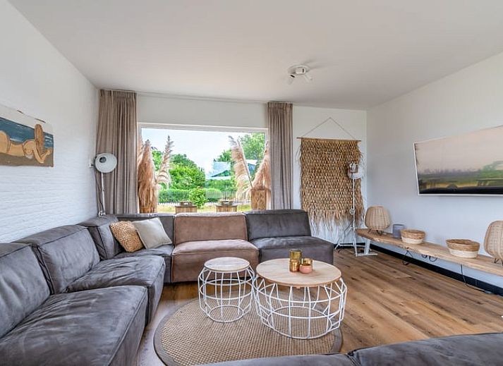 Eetkamer in Huisje in De Koog, Texel, met grote tafel en uitzicht op de natuur van de Waddeneilanden.