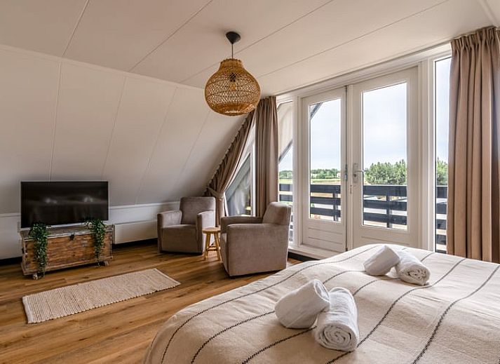 Moderne woonkamer in Huisje in De Koog, Texel, met comfortabele bank en uitzicht op de Waddeneilanden.