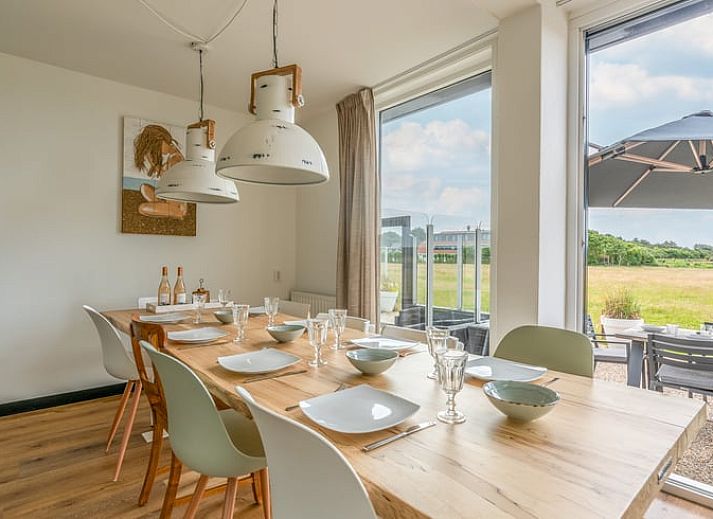 Moderne woonkamer in Huisje in De Koog, Texel, met comfortabele bank en uitzicht op de Waddeneilanden.