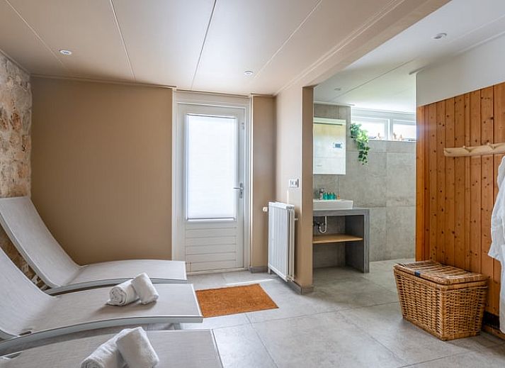 Moderne woonkamer in Huisje in De Koog, Texel, met comfortabele bank en uitzicht op de Waddeneilanden.