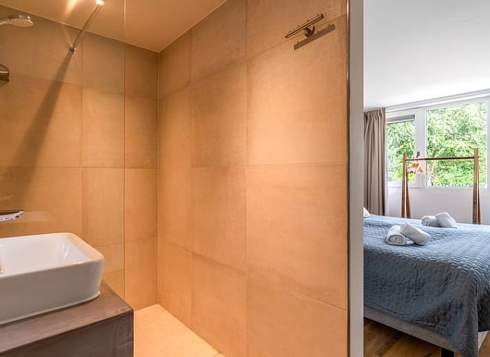 Moderne woonkamer in Huisje in De Koog, Texel, met comfortabele bank en uitzicht op de Waddeneilanden.