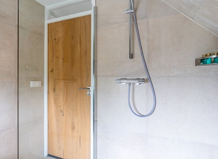 Moderne woonkamer in Huisje in De Koog, Texel, met comfortabele bank en uitzicht op de Waddeneilanden.