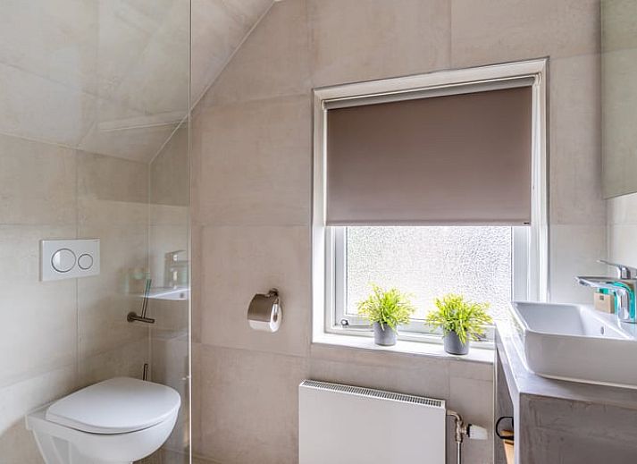 Stijlvolle badkamer in Huisje in De Koog, Texel, met moderne douche en wastafel.