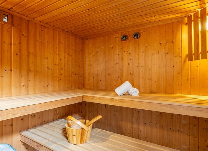 Sfeervolle slaapkamer in Huisje in De Koog, Texel, met dakraam en houten accenten.