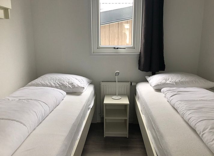 Chaletpark Bregkoog 226 in De Koog, Texel mit sonnigem Vorgarten und bequemen Stuehlen.