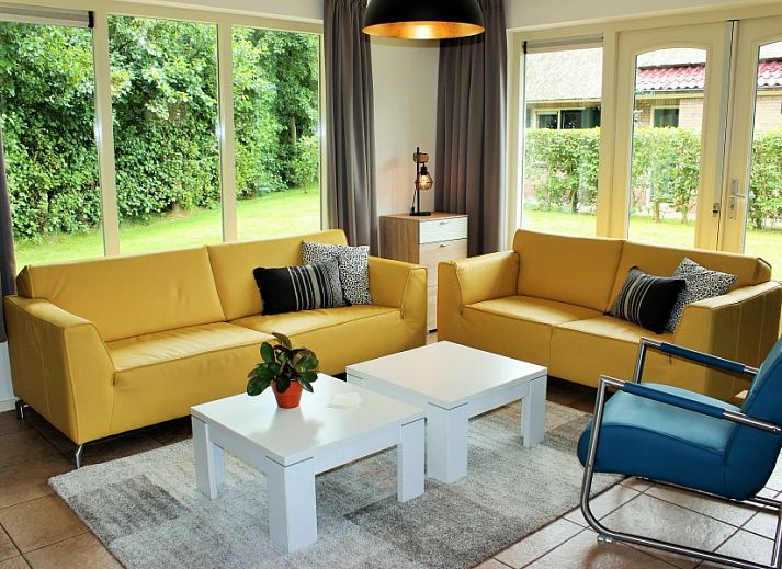 Gemuetliches Wohnzimmer im reetgedeckten 6-Personen-Ferienhaus Eldorado Texel, De Koog, mit moderner Einrichtung und Gartenblick.