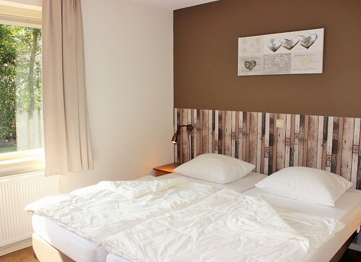 Gemuetliches Wohnzimmer im reetgedeckten 6-Personen-Ferienhaus Eldorado Texel, De Koog, mit farbenfrohen Moebeln und moderner Kueche, ideal zum Entspannen.