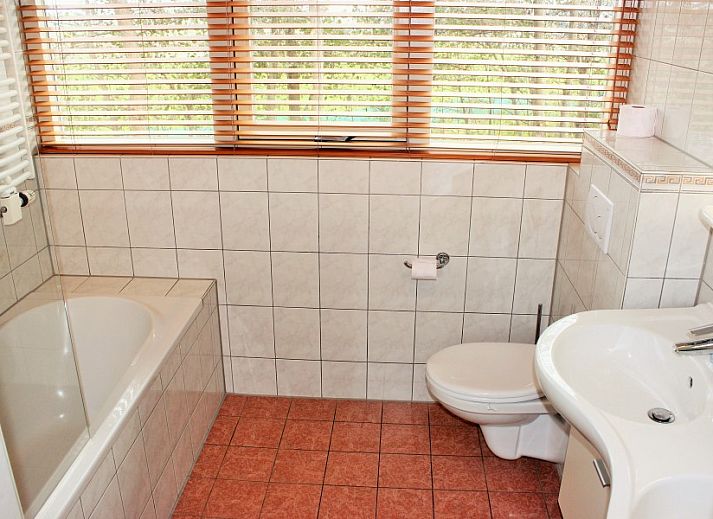 Gemuetliches Wohnzimmer im reetgedeckten 6-Personen-Ferienhaus Eldorado Texel, De Koog, mit farbenfrohen Moebeln und moderner Kueche, ideal zum Entspannen.