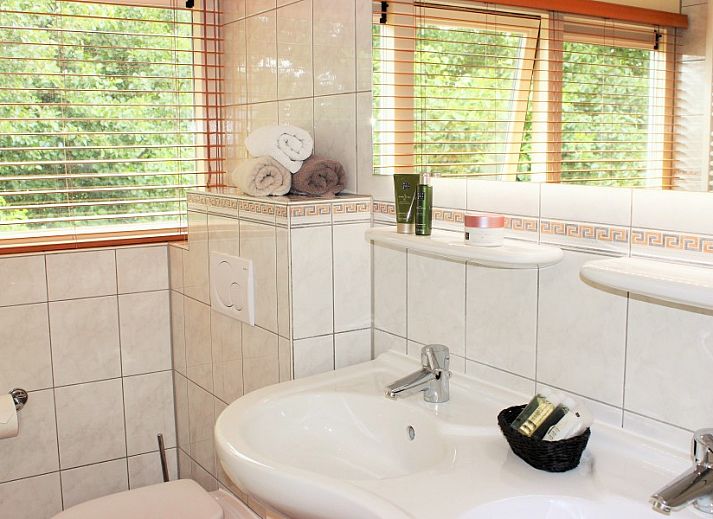 Moderne Kueche im reetgedeckten 6-Personen-Ferienhaus Eldorado Texel, De Koog, mit Essecke und Blick auf die gruene Umgebung der Waddeninseln.