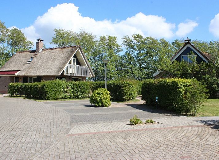 Moderne Kueche im reetgedeckten 6-Personen-Ferienhaus Eldorado Texel, De Koog, mit Essecke und Blick auf die gruene Umgebung der Waddeninseln.