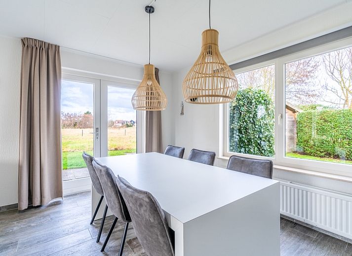 Zijaanzicht van Vakantiehuis Kamperfoelie 67, De Koog, Texel. Geniet van het terras en de groene omgeving op de Waddeneilanden.