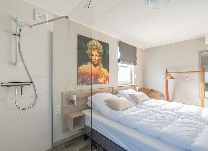 Zijaanzicht van Vakantiehuis Kamperfoelie 67, De Koog, Texel. Geniet van het terras en de groene omgeving op de Waddeneilanden.