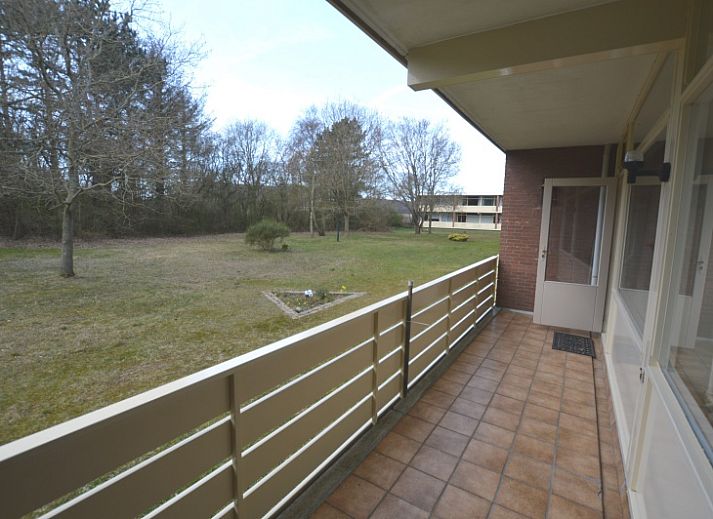 Gezellige zithoek in Appartement Kerckeland 24, De Koog, Texel met uitzicht op de tuin en veel natuurlijk licht.