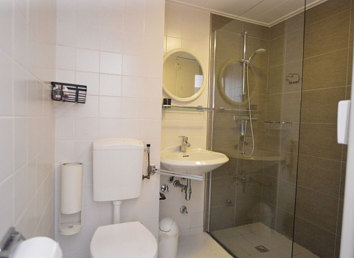 Lichte leefruimte in Appartement Kerckeland 70, De Koog, Texel met grote ramen en comfortabele stoelen.