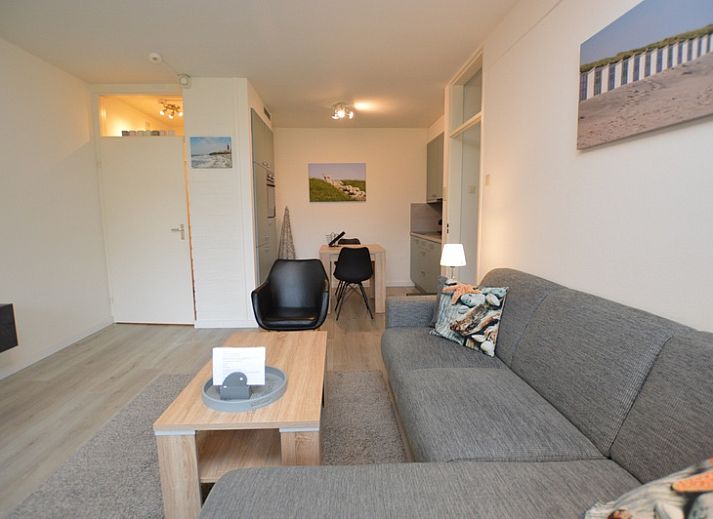 Stijlvolle woonkamer van Appartement Kerckeland 106 in De Koog, Texel met uitzicht op de groene omgeving.