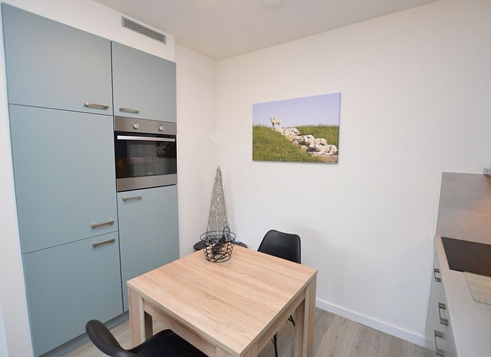 Stijlvolle woonkamer van Appartement Kerckeland 106 in De Koog, Texel met uitzicht op de groene omgeving.