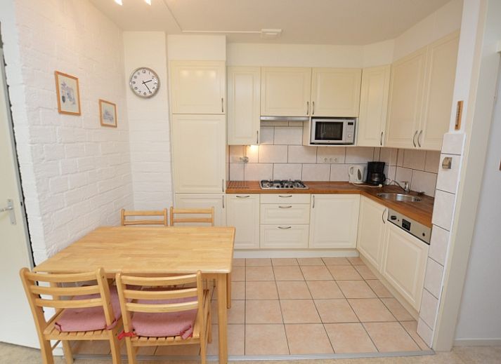 Lichte leefruimte in Appartement Kerckeland 28, De Koog, Texel, met grote ramen en een uitnodigende sfeer.