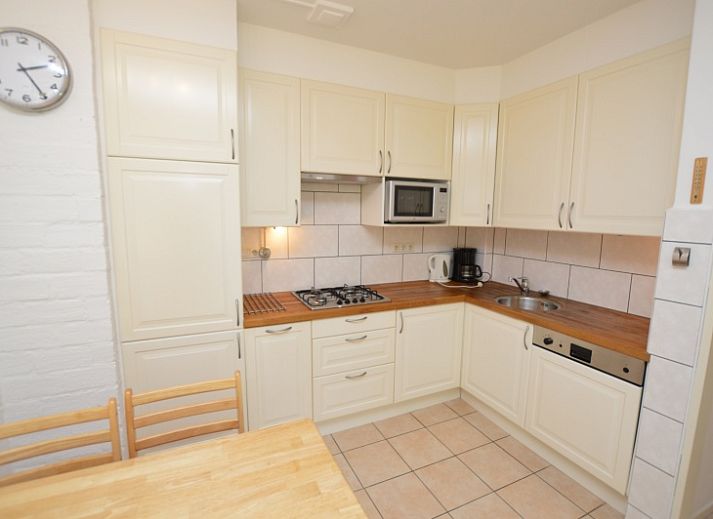 Lichte leefruimte in Appartement Kerckeland 28, De Koog, Texel, met grote ramen en een uitnodigende sfeer.