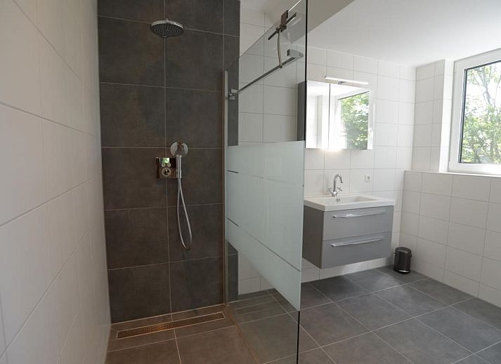 Modern living room in 06 - Razende Bol - allotment vacation home in De Koog, Texel with open kitchen.