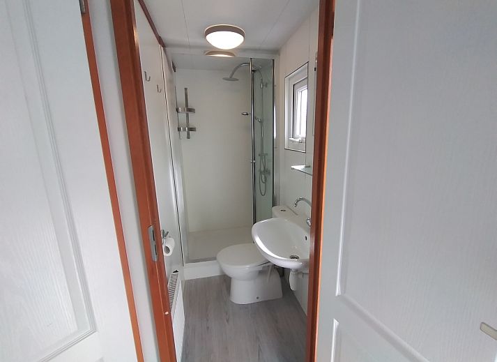 Moderne woonkamer van Chalet Uit en Thuis, Texel, met uitzicht op de tuin en comfortabele stoelen.