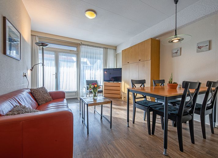 Gezellige woonkamer in Motel Texel Appartement met bad in De Koog, Texel, met comfortabele zithoek en veel natuurlijk licht.
