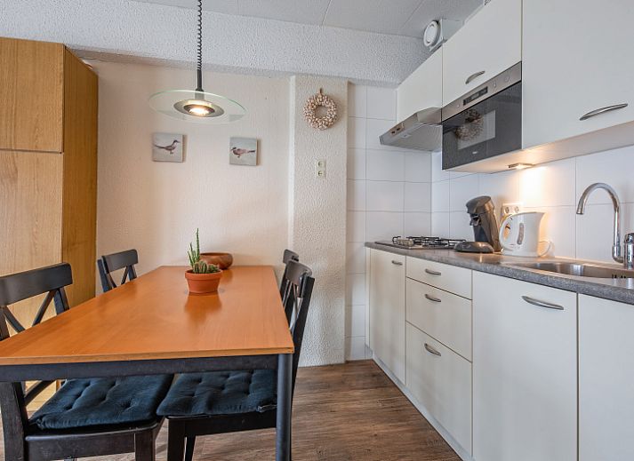 Gezellige woonkamer in Motel Texel Appartement met bad in De Koog, Texel, met comfortabele zithoek en veel natuurlijk licht.