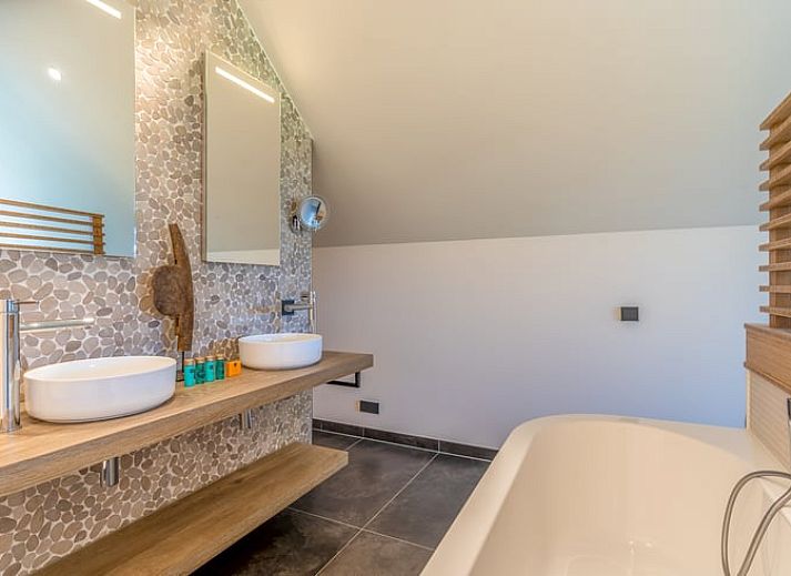 Lichte woonkamer in Vakantiehuisje in De Koog met grote ramen en uitzicht op de natuur van Texel.