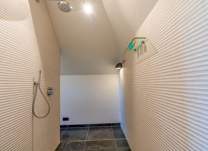 Lichte woonkamer in Vakantiehuisje in De Koog met grote ramen en uitzicht op de natuur van Texel.