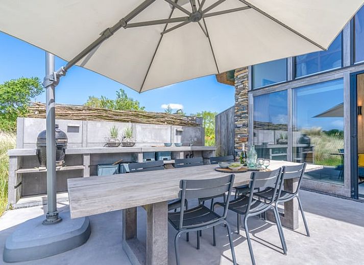 Lichte woonkamer in Vakantiehuisje in De Koog met grote ramen en uitzicht op de natuur van Texel.