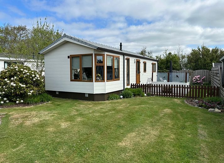 Chaletpark Bregkoog - Bregkoog chalet 214 in De Koog, Texel met groene tuin en houten omheining, ideaal voor een ontspannen vakantie.