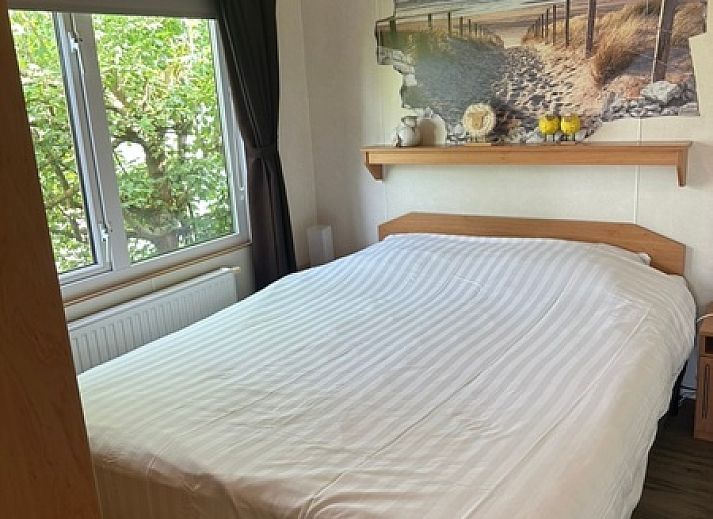 Gezellige eetruimte in Chaletpark Bregkoog, chalet 214 in De Koog, Texel, met kunst aan de muur en een uitnodigende sfeer.