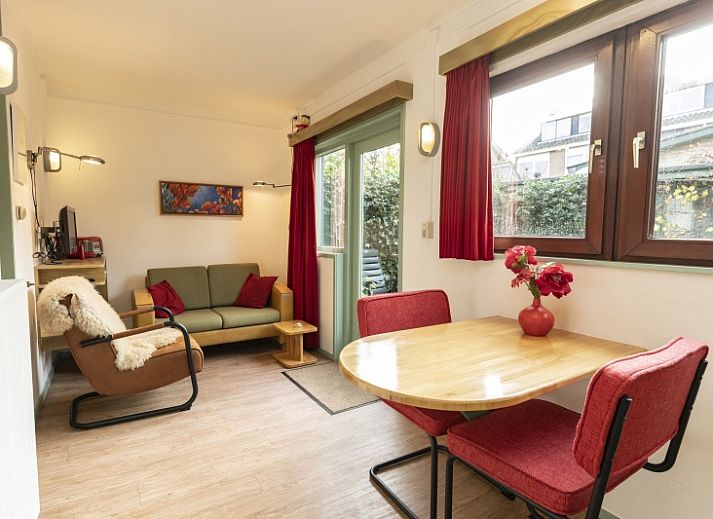 Entree van vakantiehuis Schanulleke in De Koog, Texel, Waddeneilanden met groene deur en bloeiende planten.