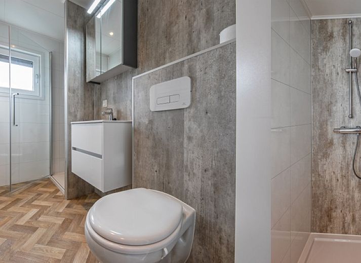 Sfeervolle zithoek in Chalet Bregkoog 162, Chaletpark Bregkoog, De Koog, Texel, met moderne kunst aan de muur.