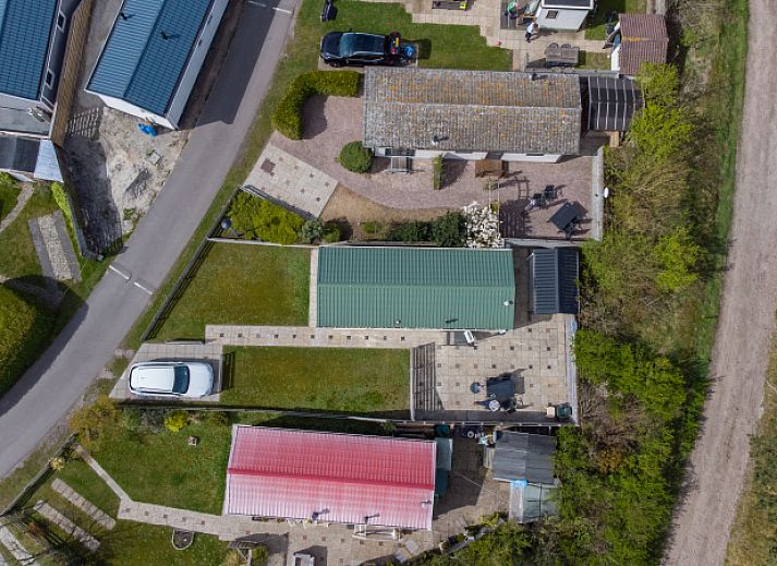 Vooraanzicht van Chalet Bregkoog 205 in De Koog, Texel, met groene omgeving en uitnodigende entree.