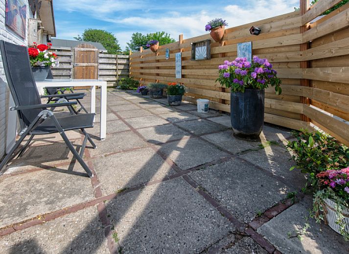 Gezellig terras bij Vakantiehuis 2490 in De Koog, Texel met bloemen en zitje.