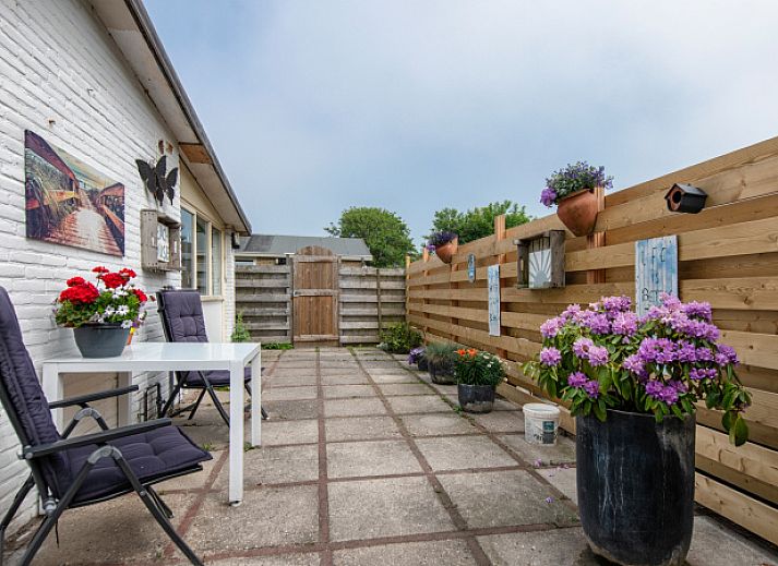 Gezellig terras bij Vakantiehuis 2490 in De Koog, Texel met bloemen en zitje.