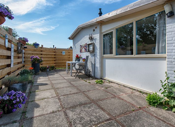 Gezellig terras bij Vakantiehuis 2490 in De Koog, Texel met bloemen en zitje.