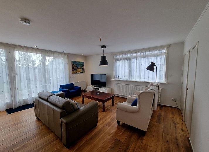 Gemuetliches Wohnzimmer im Bungalow Epelaan 13, De Koog, Texel. Geraeumiges Ferienhaus mit bequemen Sitzgelegenheiten und viel natuerlichem Licht.